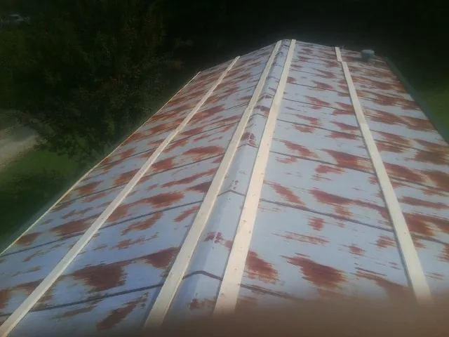 Rusted metal roof panels with new wood purlins before replacement — Storm Damage Roof Repair in Beulah by Roofing Brothers