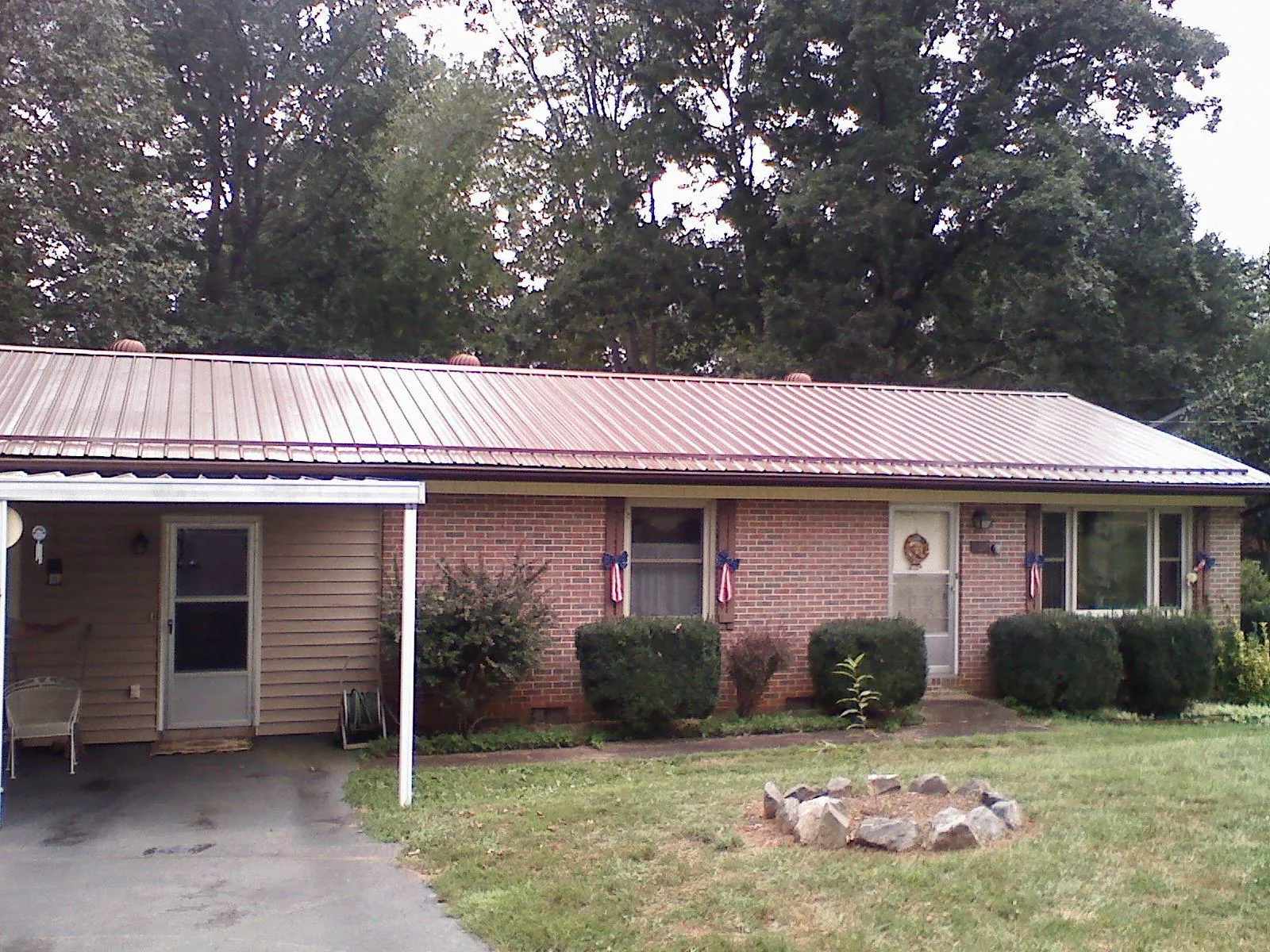Bronze metal roof and carport on a brick ranch home — Roof Repair work by our crew in Beulah